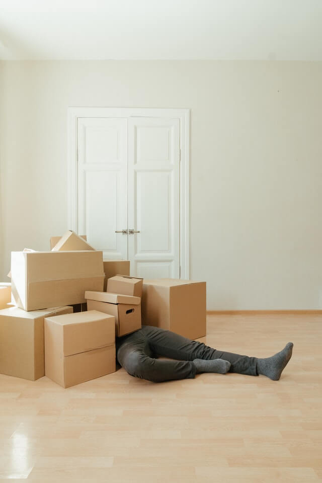 A man laying on the floor with boxes in front of him.