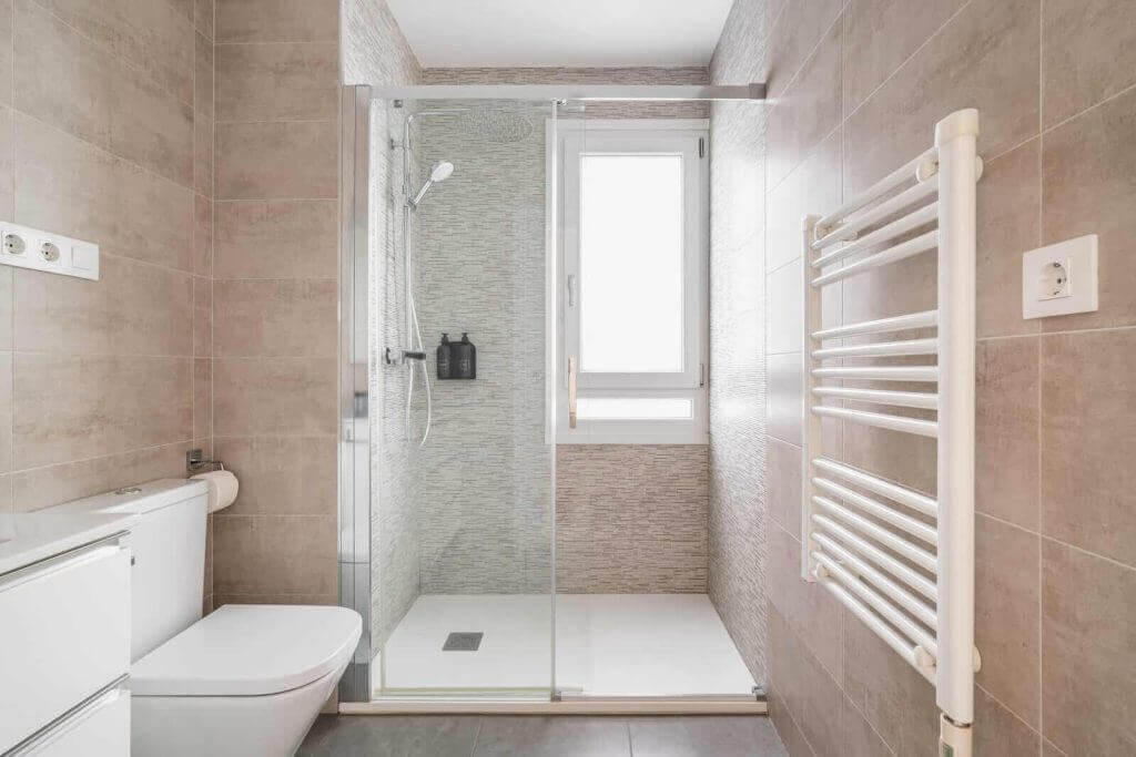 A bathroom with a shower stall and a toilet.