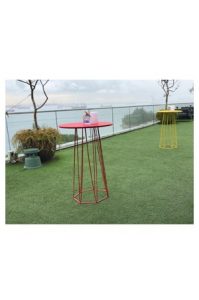 A Hexagon Bar Table™ on a grassy area with a view of the ocean.