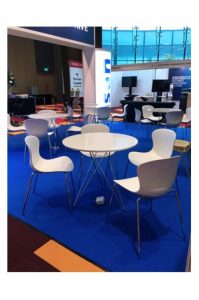 A blue carpet with Replica Nap chairs and tables.