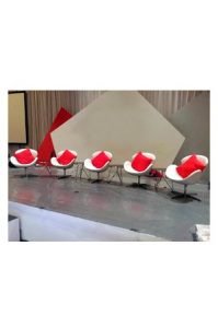 A group of Replica Swan Chairs - Single Seater in white and red on a stage.