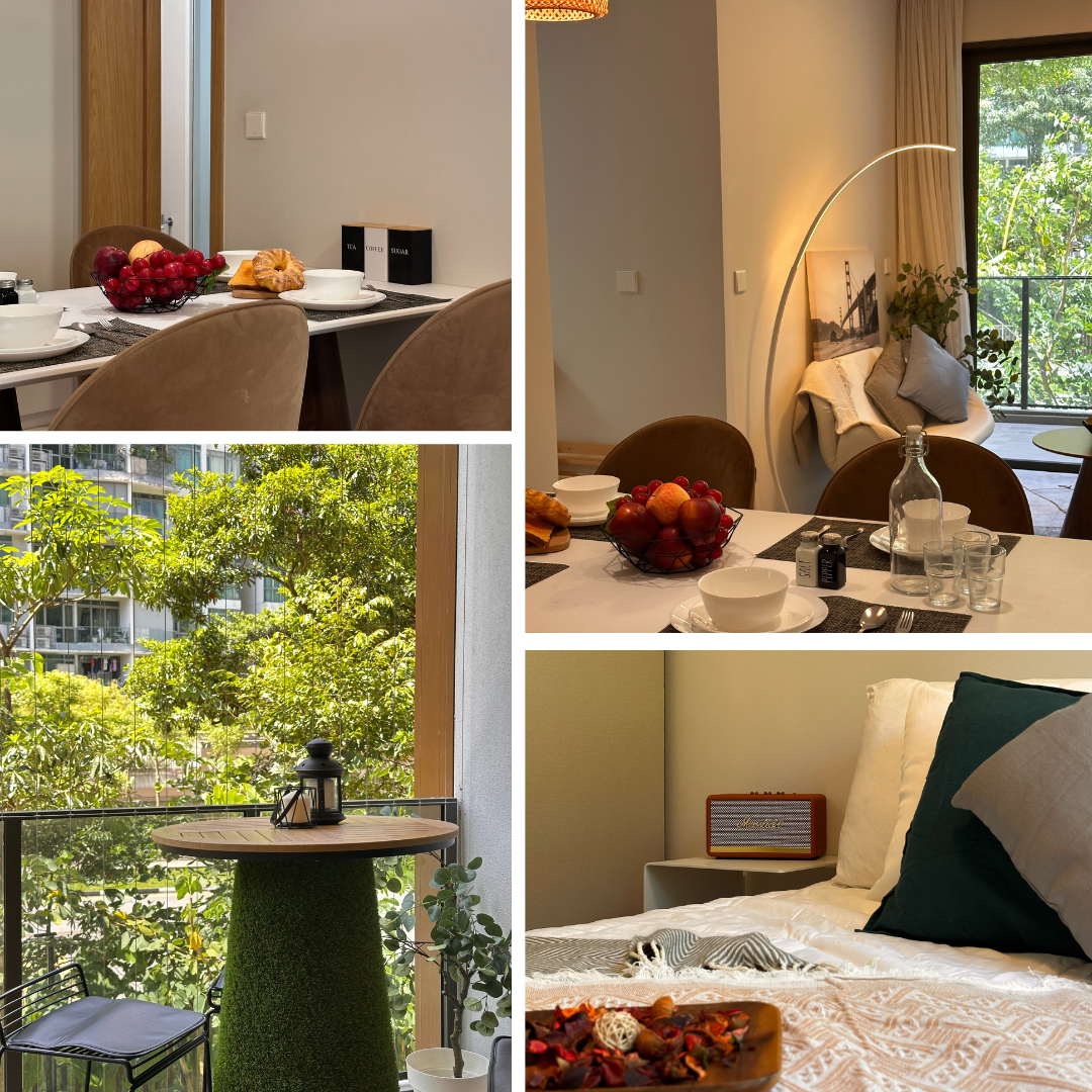 A modern apartment interior features a dining area, a cozy bedroom, and a small balcony table with outdoor greenery visible through large windows.