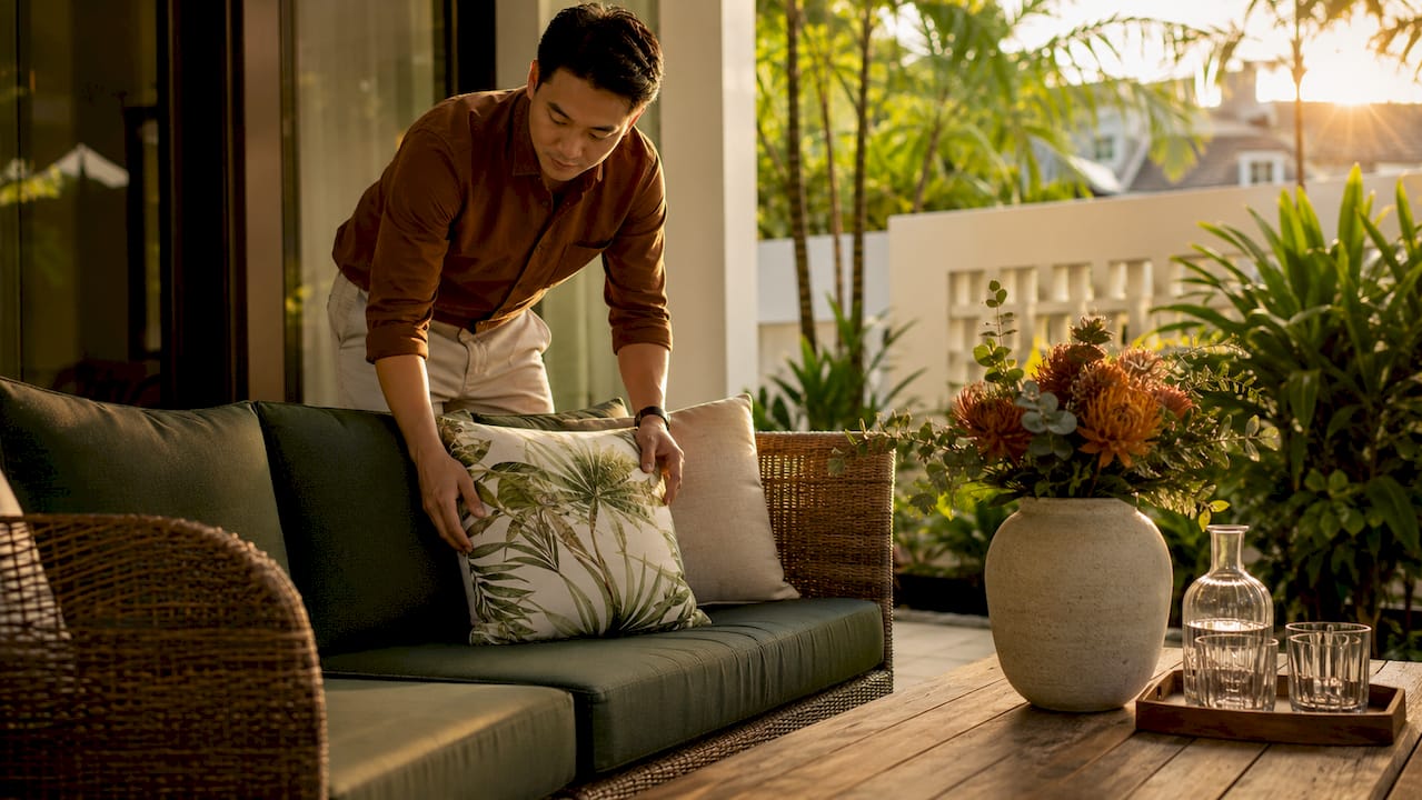 Interior stager arranging sofa cushions in landed home