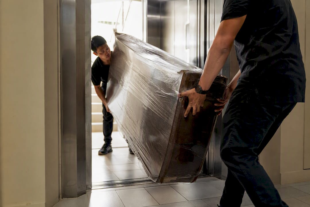 Delivery team handling furniture in HDB lift